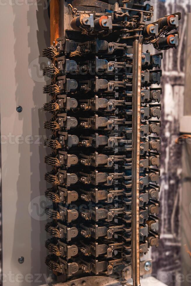 A detailed view of a historical mechanical device featuring intricate gears and levers, displayed in a museum setting, likely in London. photo