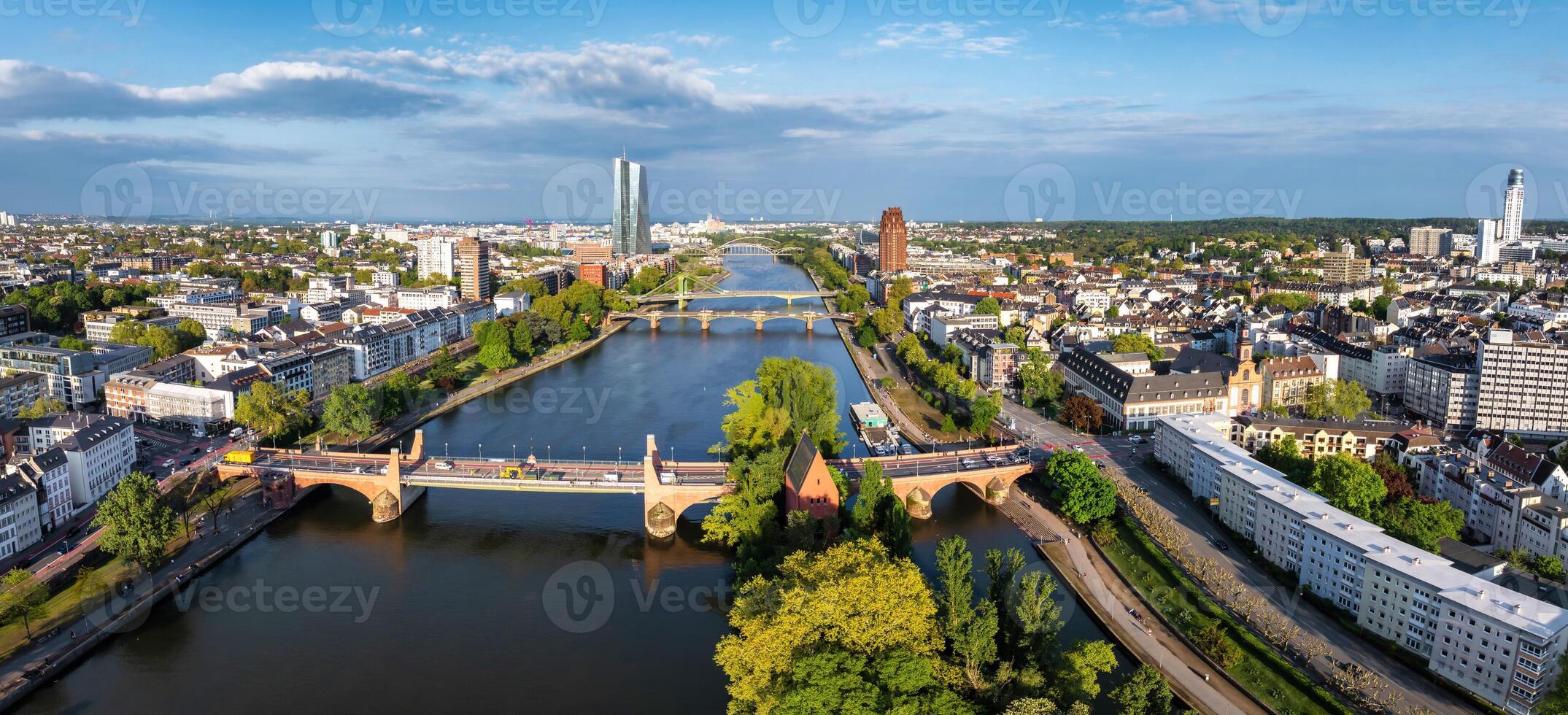 Aerial image of Frankfurt, Germany, featuring the Main River, Alte Brucke, European Central Bank skyscraper, historic buildings, and lush greenery. photo