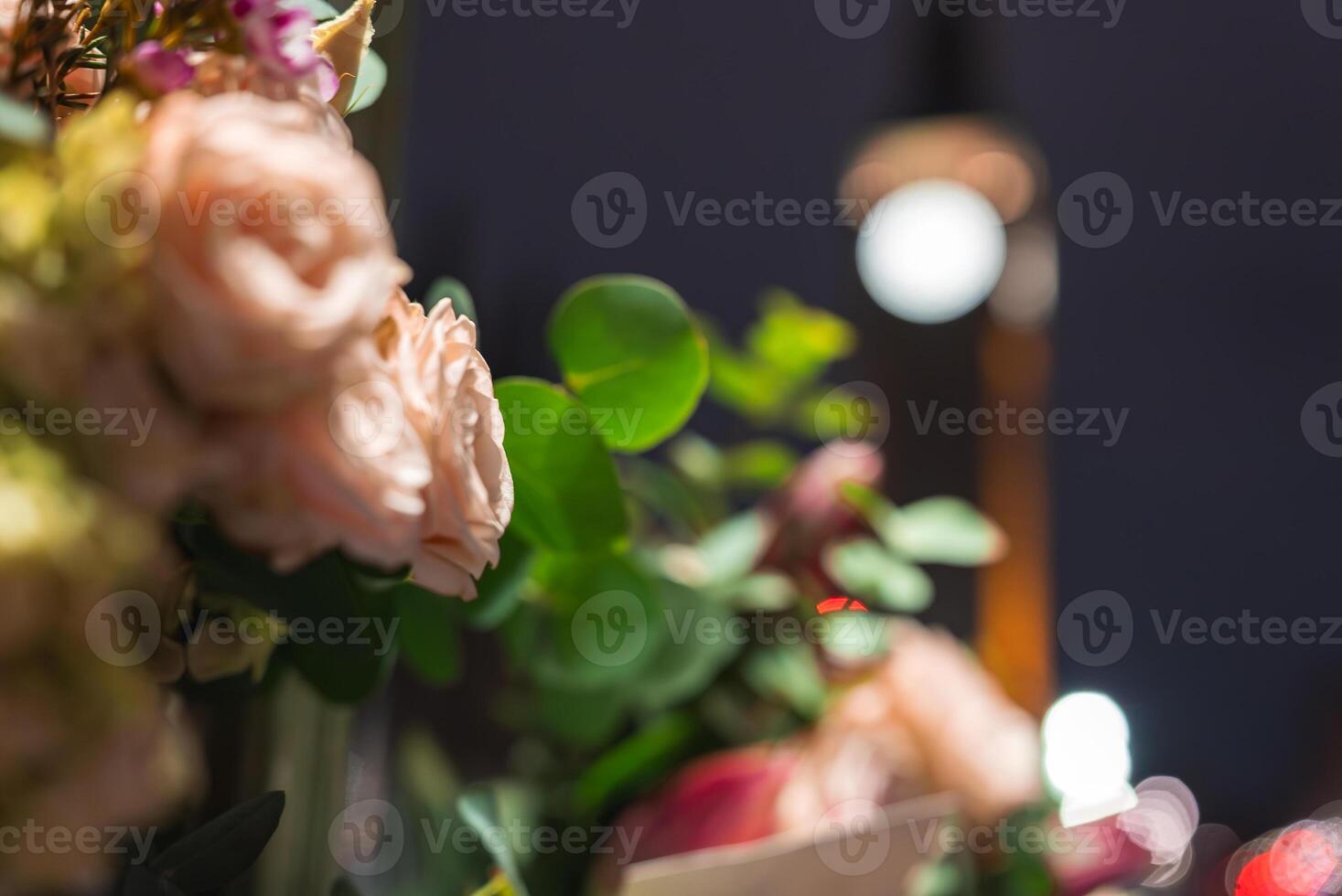 Soft pink roses and green foliage in focus, with Big Ben glowing against the night sky in the background. A blend of nature and iconic architecture. photo