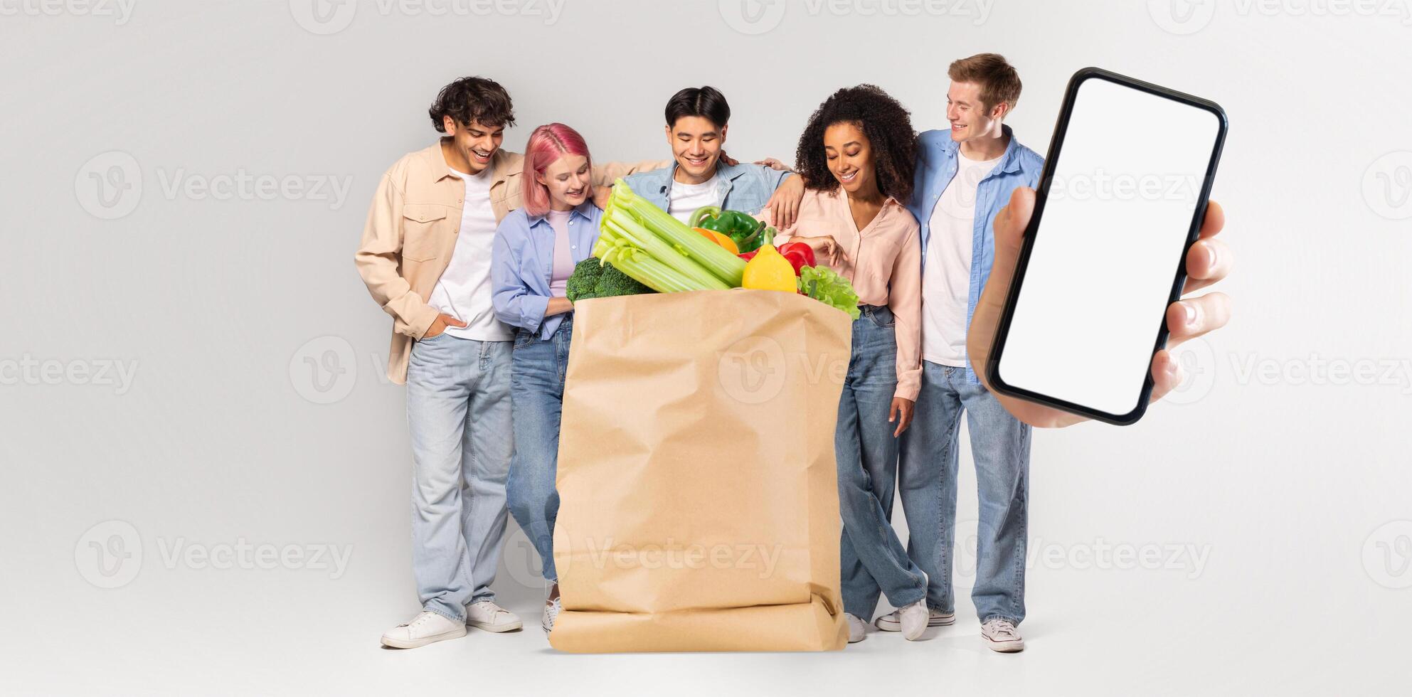 A group of five customers stands together, smiling and enjoying their groceries in a light-filled space. One person holds a smartphone, reflecting a new era of shopping and delivery. photo