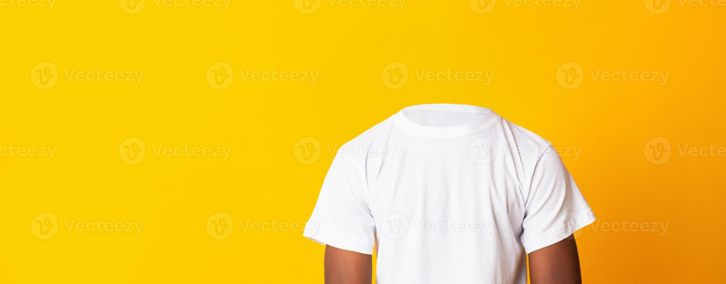 A headless person is wearing a plain white t-shirt, standing against a vibrant yellow backdrop. The lack of a head creates a unique and isolated visual effect, emphasizing lifestyle themes. photo