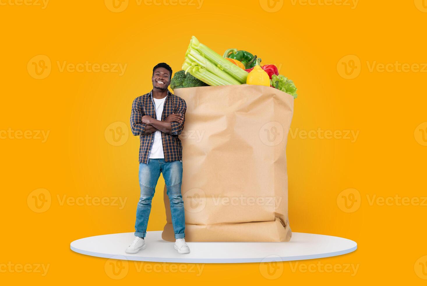 A customer stands confidently beside a large paper bag filled with fresh vegetables and fruits, embodying a new normal in grocery shopping amid remote delivery options. photo