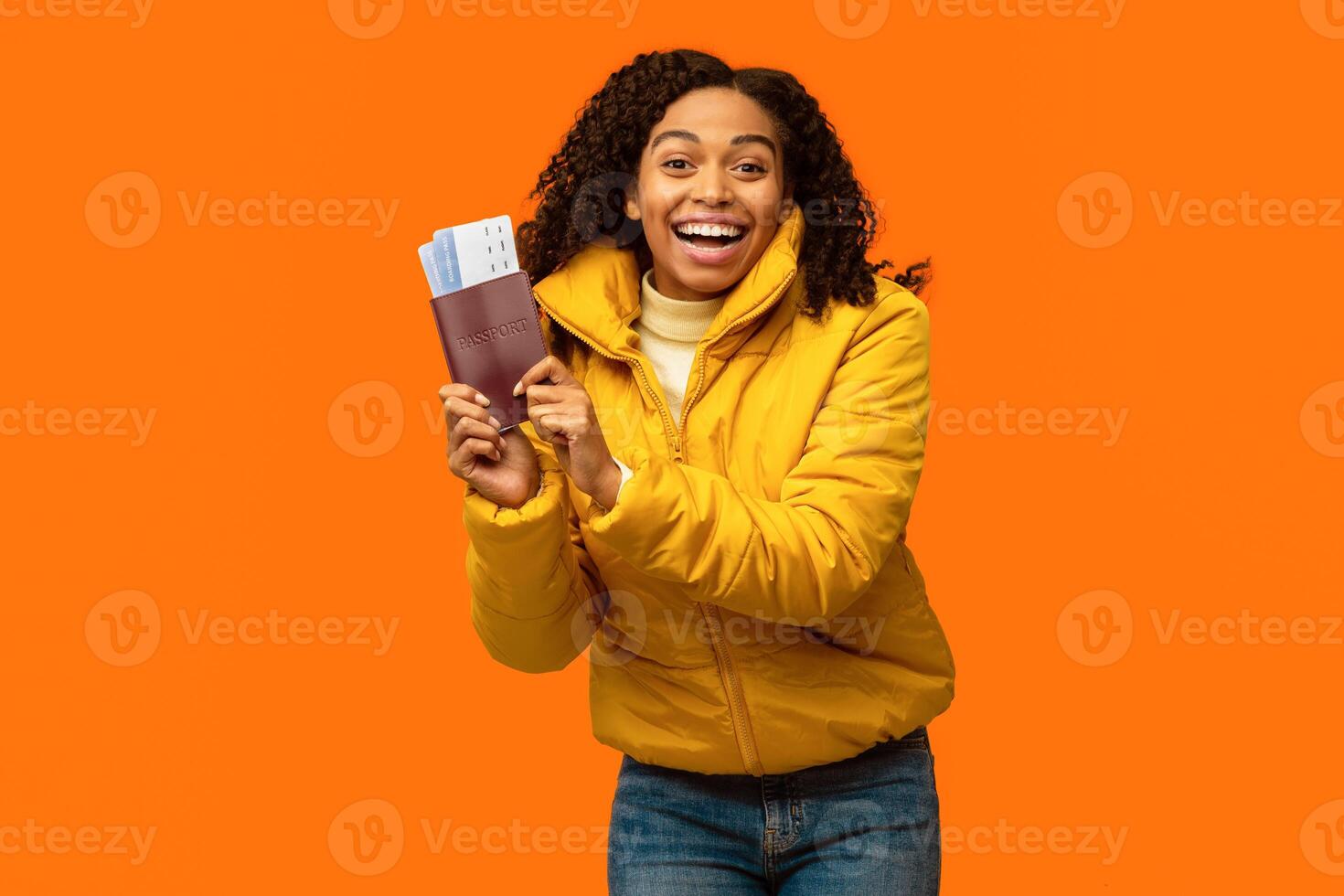 Winter Vacation. Happy Black Travel Girl Showing Flight Tickets Going On Ski Resort On Holidays Standing Over Yellow Studio Background photo