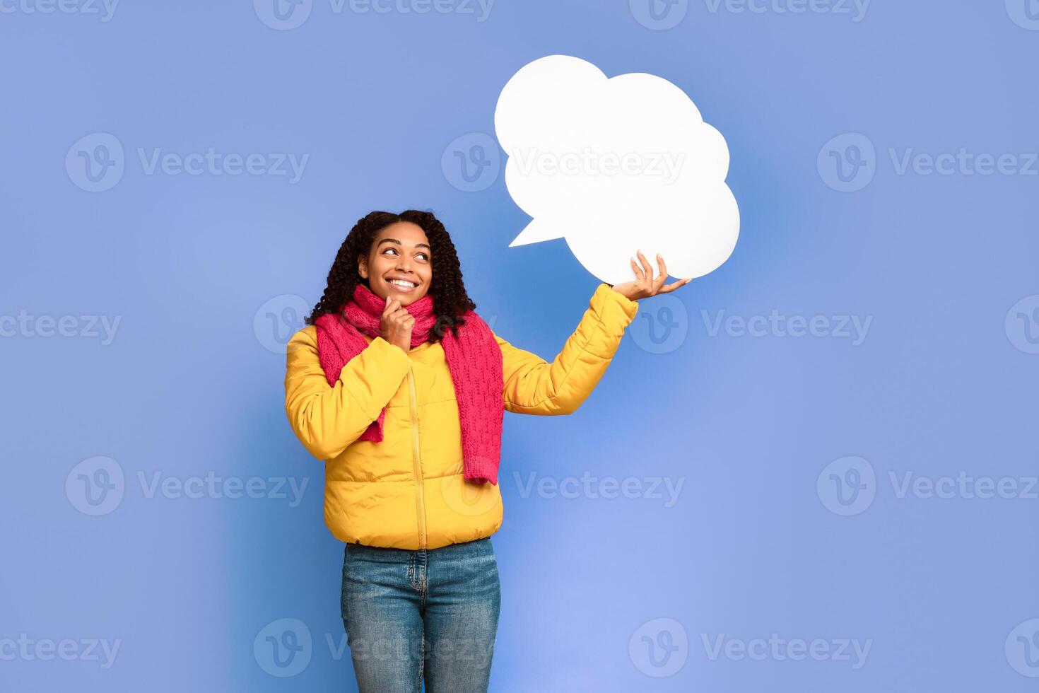 Cheerful Black Woman Holding Empty Speech Bubble Above Head Thinking Standing Posing Over Purple Studio Background, Wearing Winter Jacket And Scarf. Thought Bubble Mockup, Let Me Think Concept photo