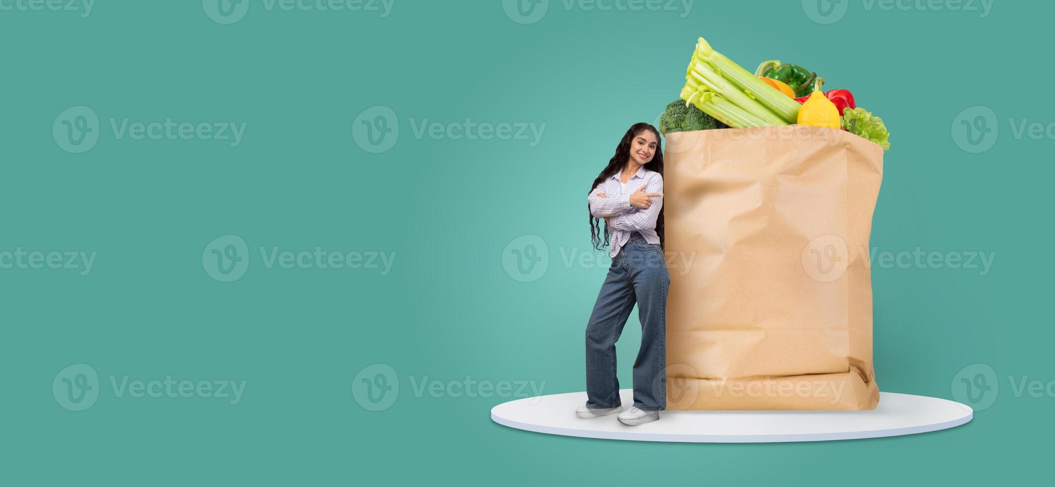 A customer stands next to a large paper bag filled with fresh groceries. She looks pleased with her purchase, symbolizing new shopping habits in a modern market environment. photo