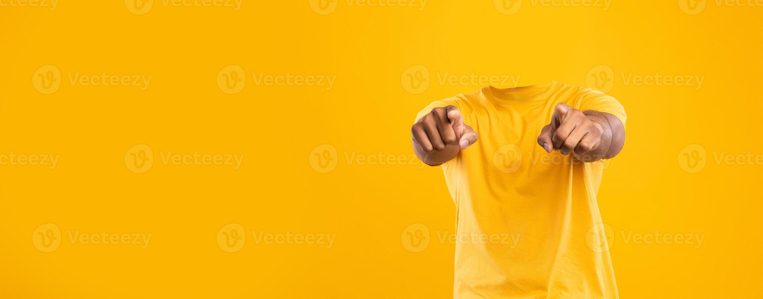 Headless individual is seen pointing toward the viewer against a bright yellow background. This isolated lifestyle portrayal emphasizes blank space and brings a unique perspective. photo