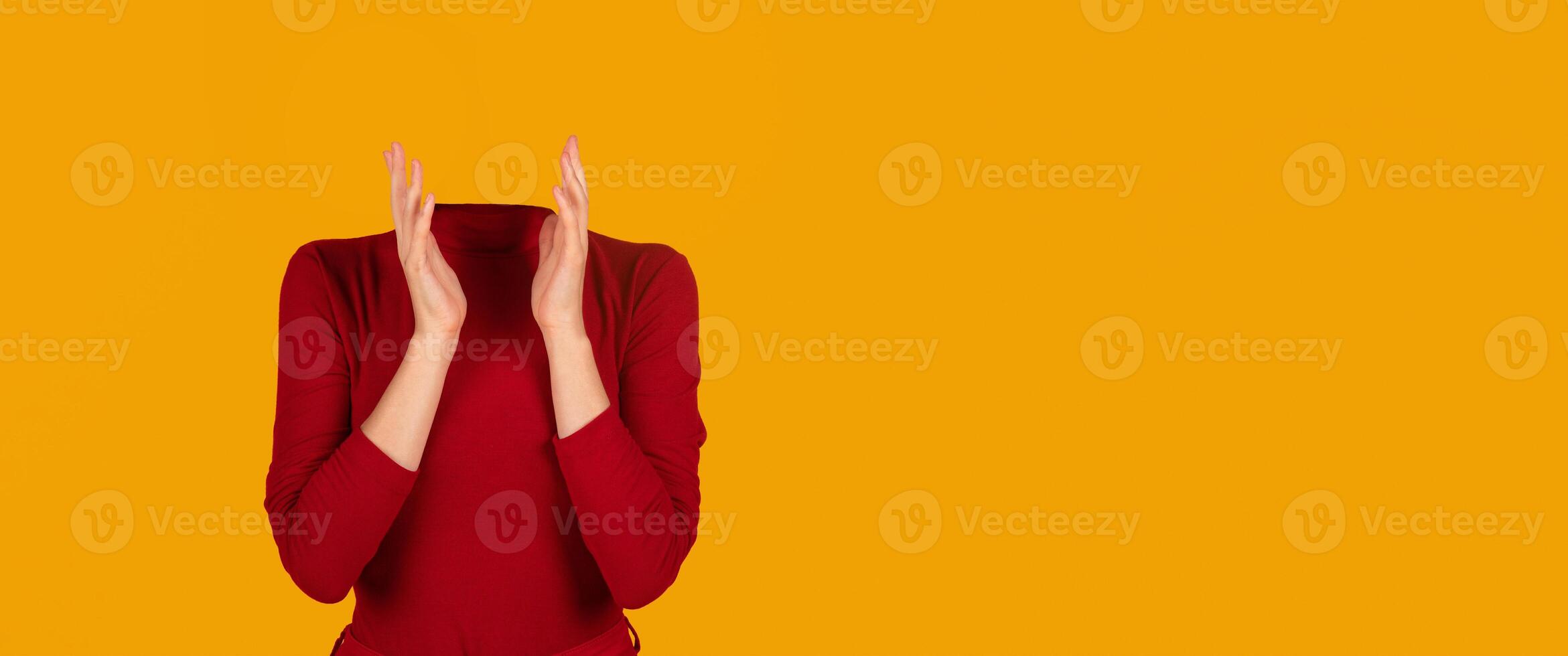 A person without a head is seen clapping their hands, dressed in a red long-sleeve top. The bright yellow background creates an isolated, artistic effect suitable for a modern collage. photo