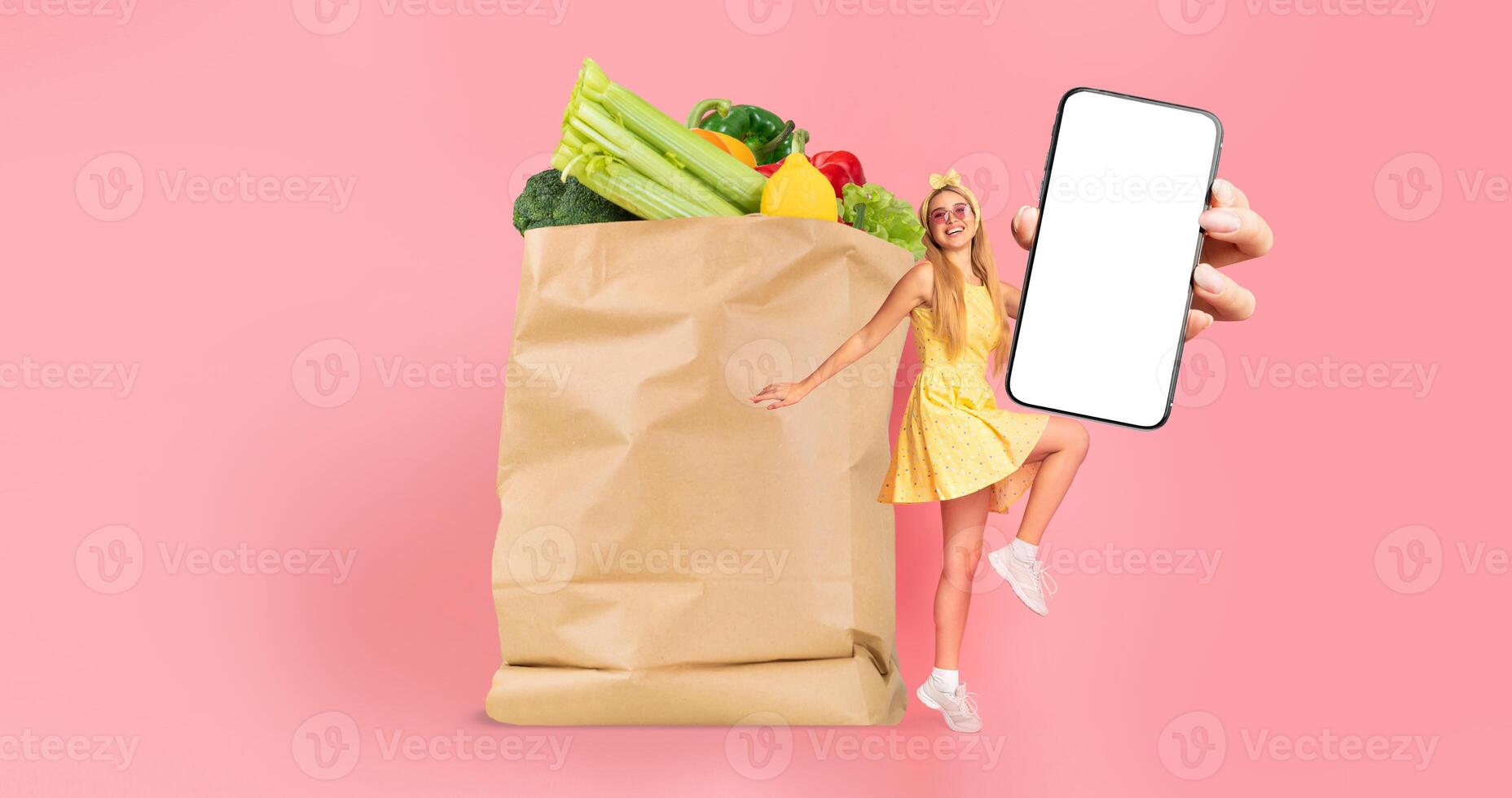 A customer holds a smartphone next to a paper bag filled with fresh produce. The background features a bright, colorful setting, emphasizing the convenience of grocery shopping and delivery. photo