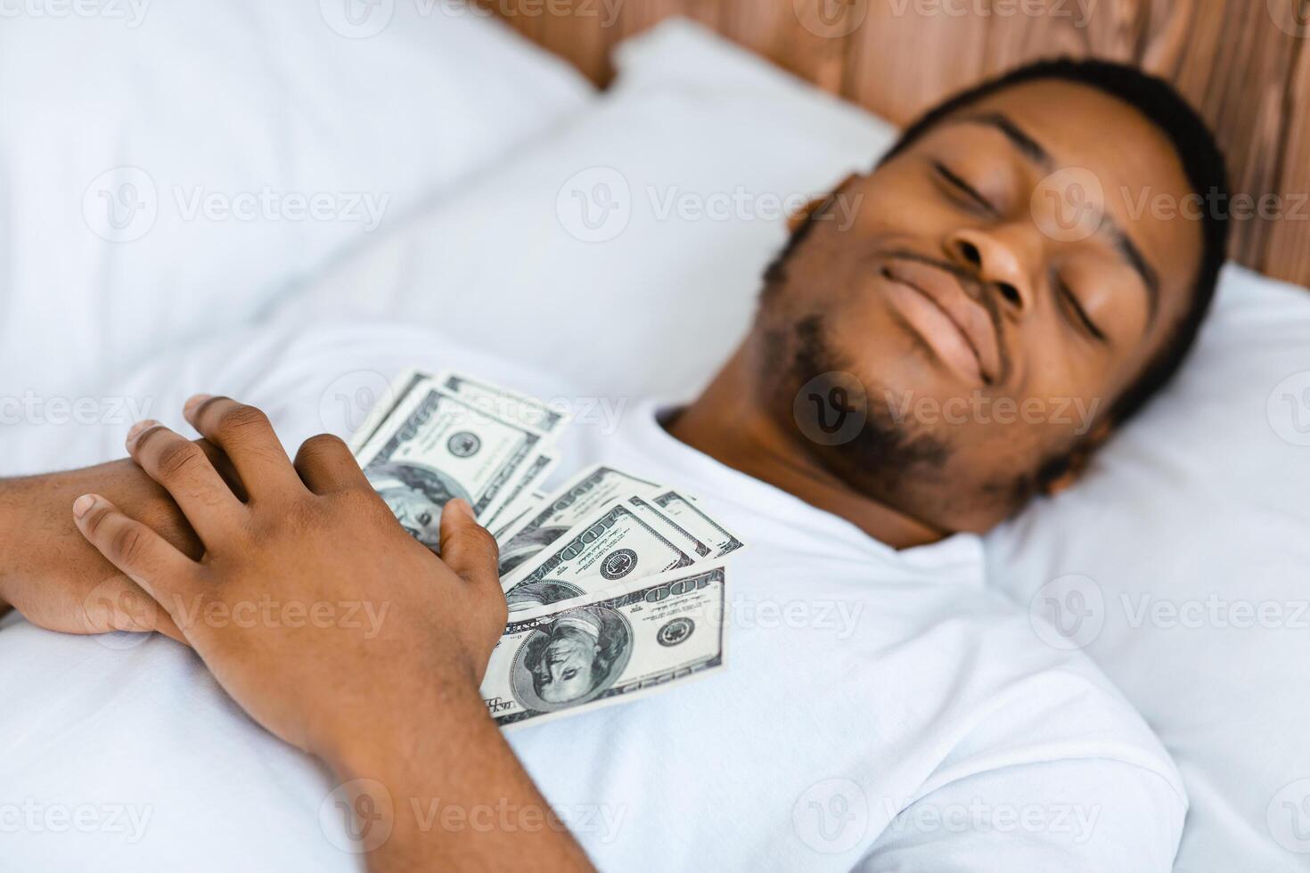 Black Man Sleeping Holding Money Hugging Cash Dollar Banknotes Dreaming About Wealth And Being Rich Lying In Bed At Home. Financial Savings And Budget, Finances Safety Concept. Selective Focus photo