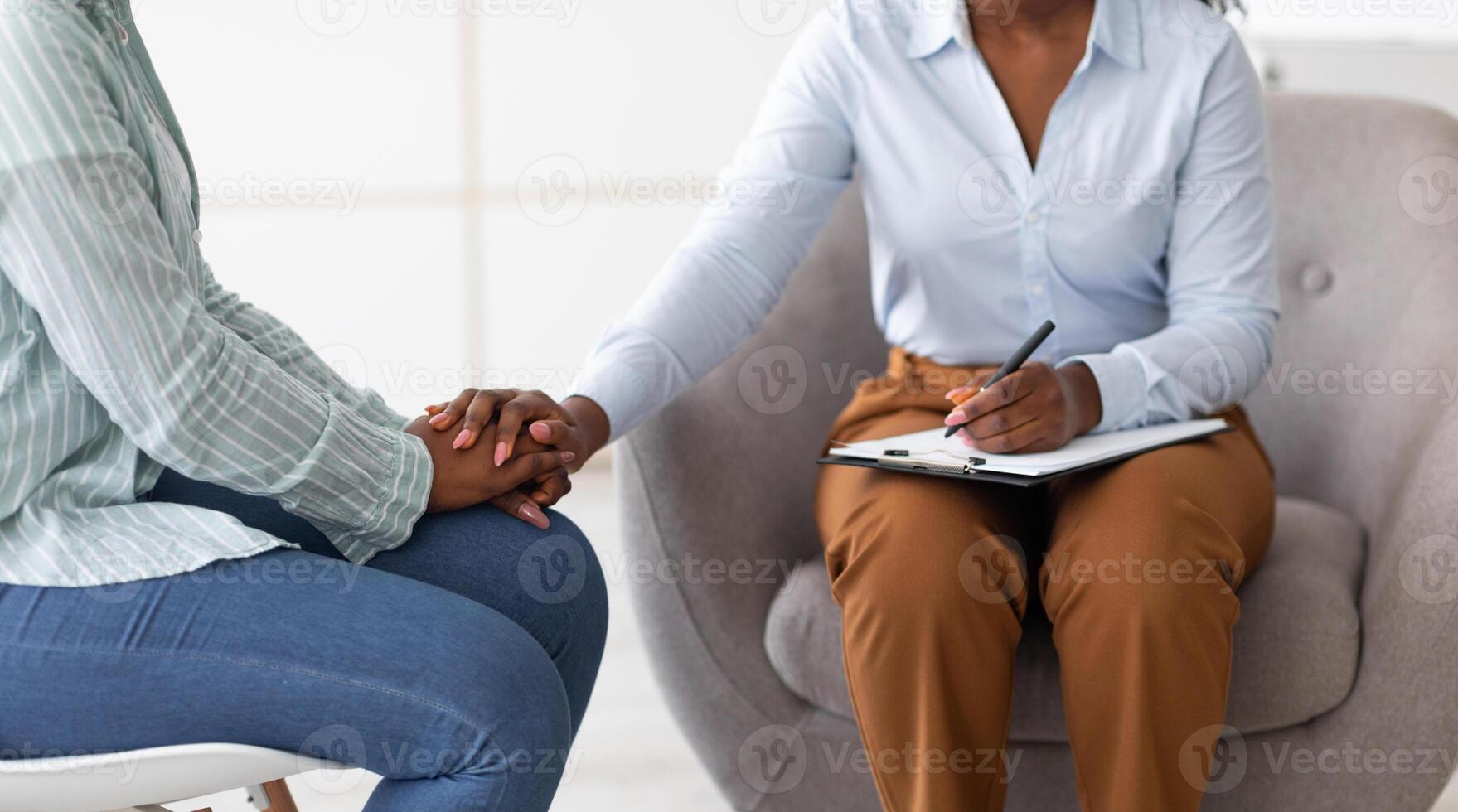 Professional support for people with mental problems. Therapist providing psychological help to female patient, holding her hand at clinic, closeup. Treatment of emotional and mood disorders photo