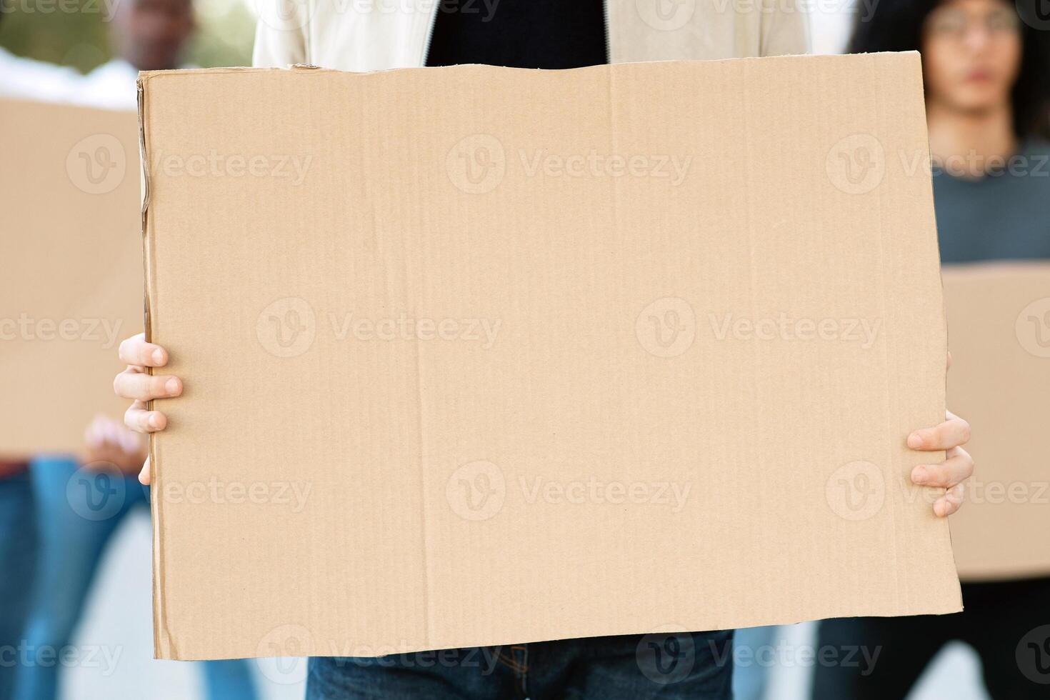 Empty placards of mutiracial group of demonstrators protesting on the street. International group of demonstrators fighting against racism, walking by the city, chanting slogans, closeup photo