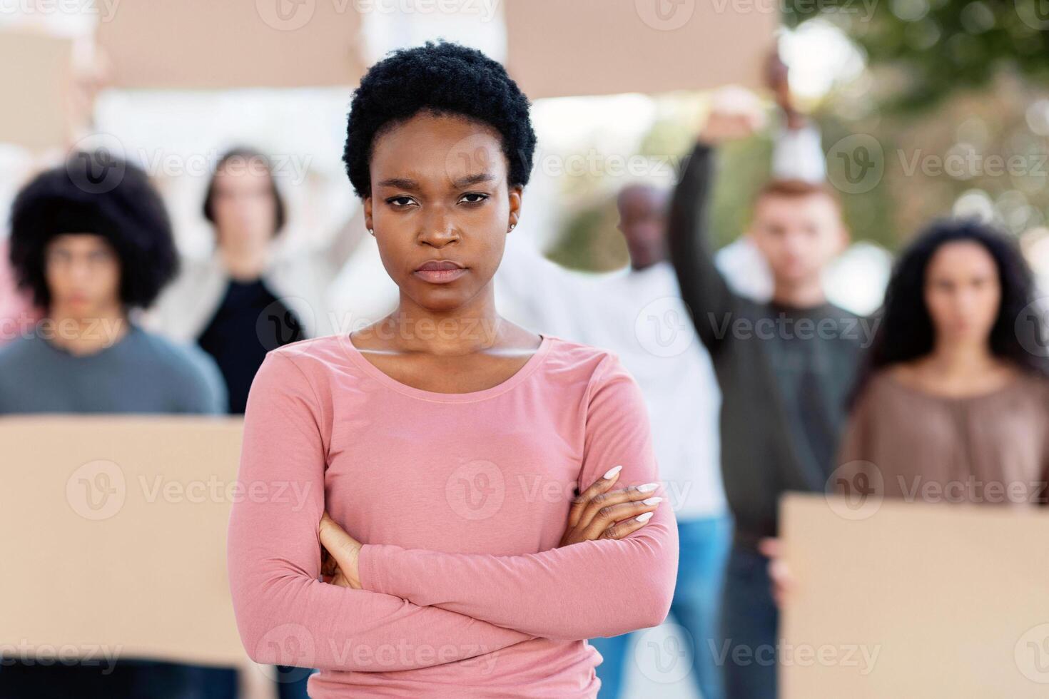Angry black lady leading multiracial group of protestors, selective focus. Millennial men and women different nationalities striking on street, holding empty boards, protesting against racism photo