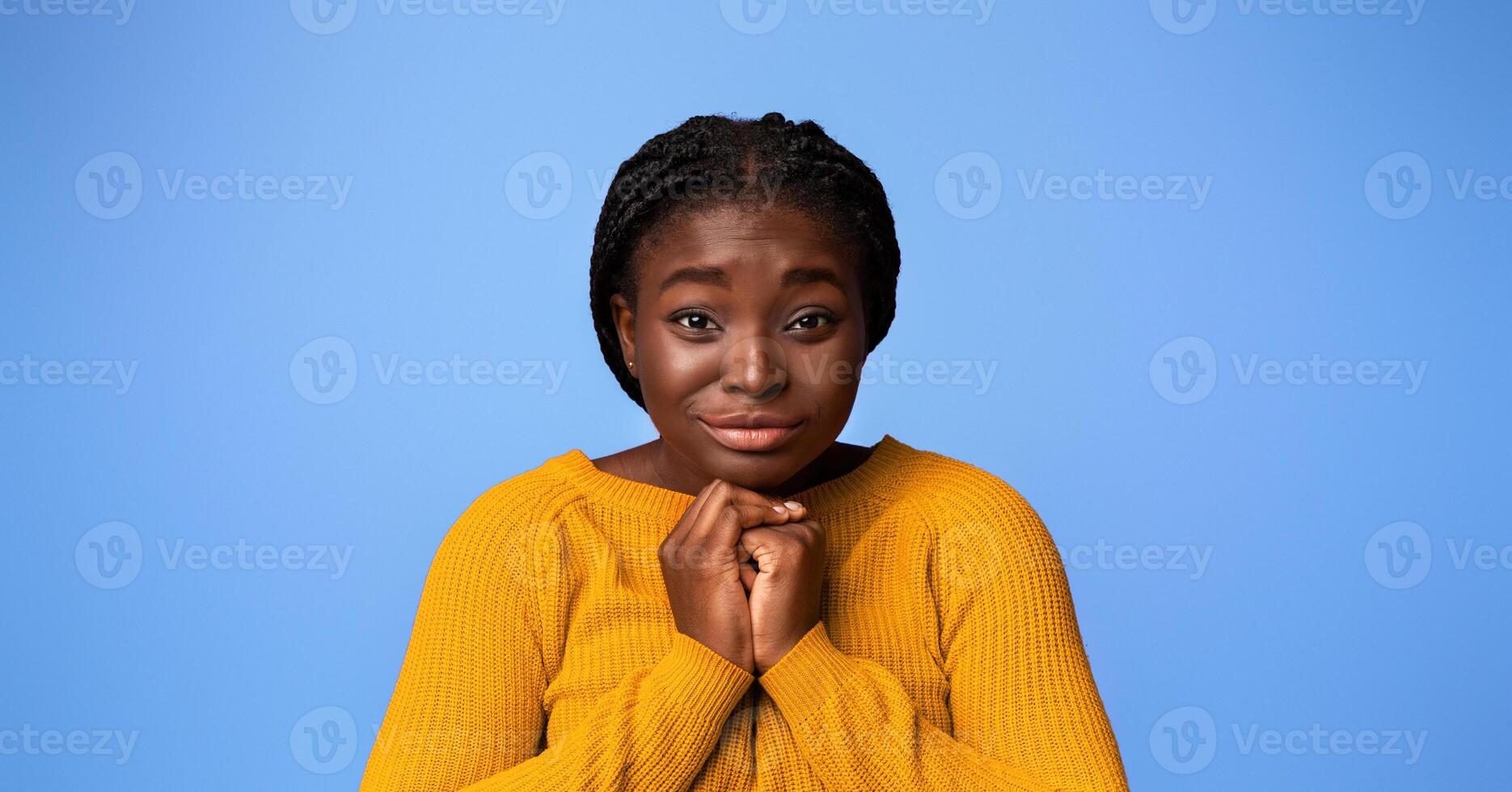 Please, Buy. Cute black woman pleading and asking for something with clasped hands, young african lady with begging face expression posing over purple studio background, looking at camera, copy space photo
