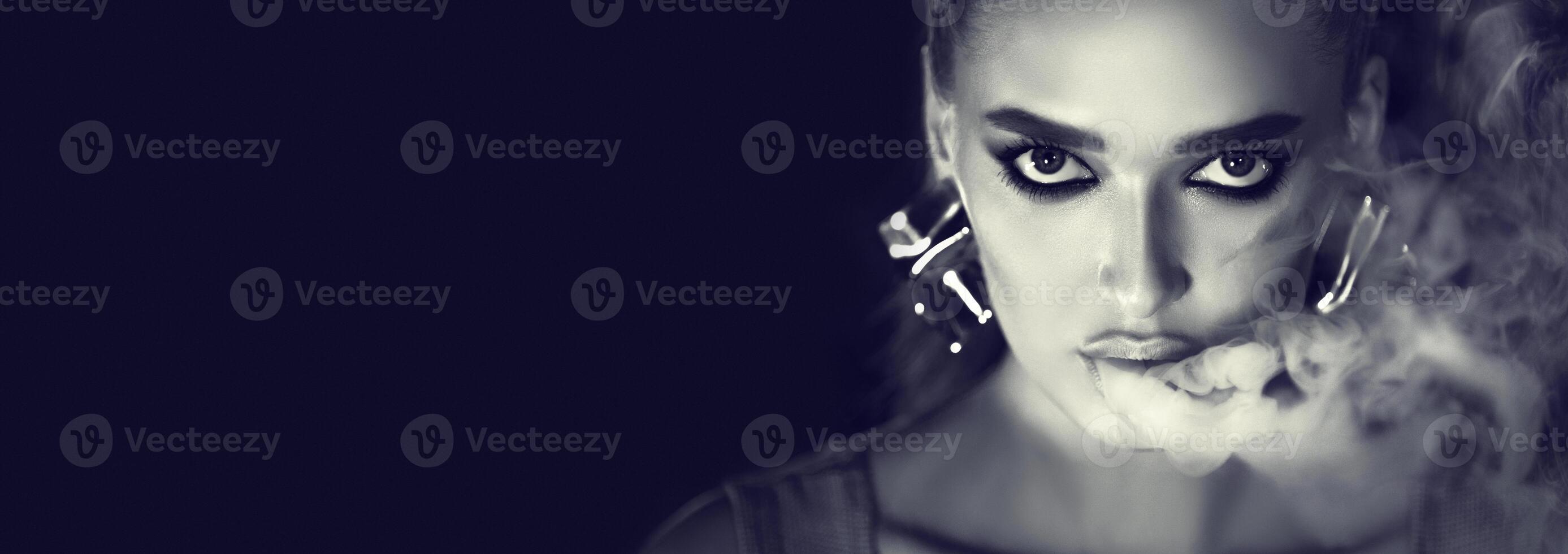 Girl Smoking E-Cigarette. Black and white portrait of woman looking at camera, copy space photo