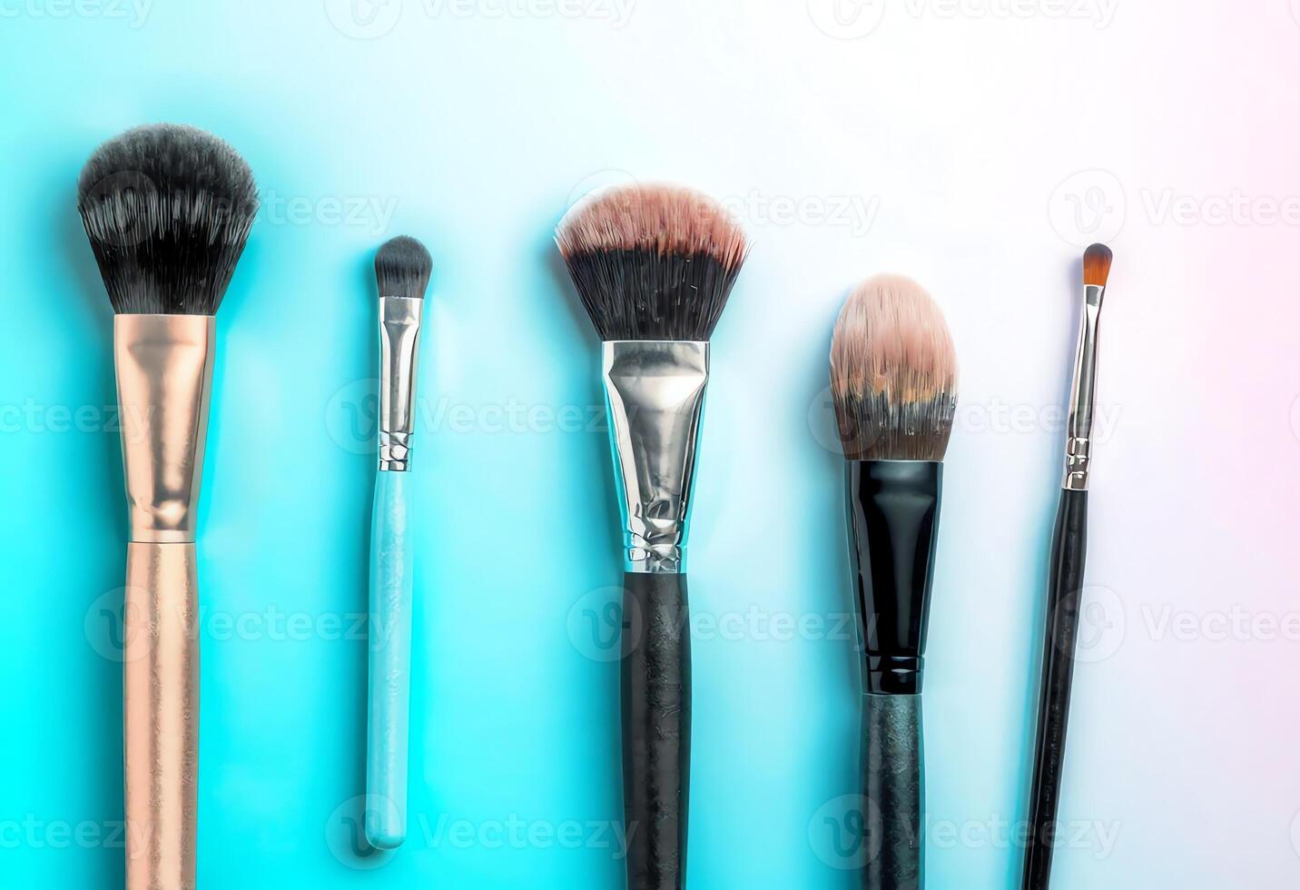 Variety of Makeup Brushes on a Gradient Background photo