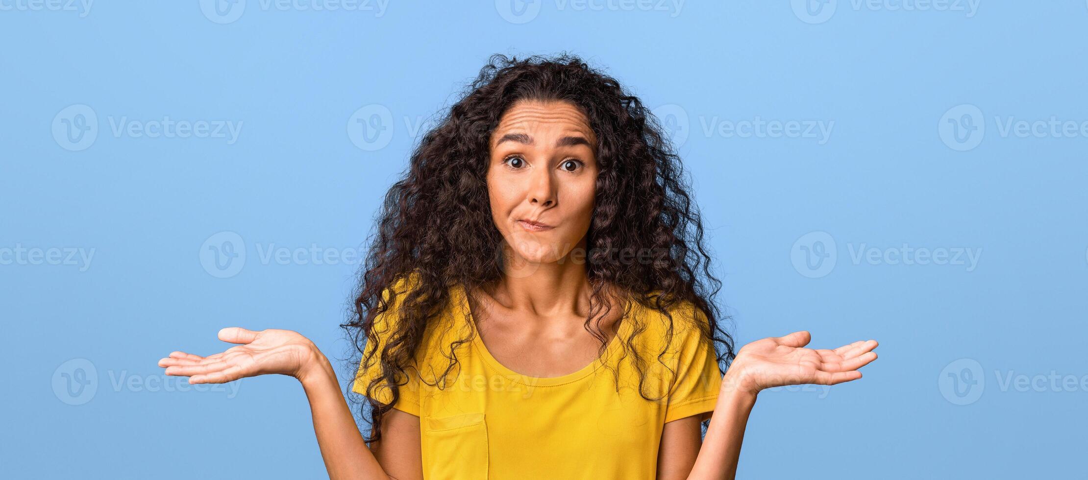 I Don't Know. Doubtful Beautiful Brunette Woman Shrugging Shoulders And Biting Lip Over Purple Studio Background, Closeup photo