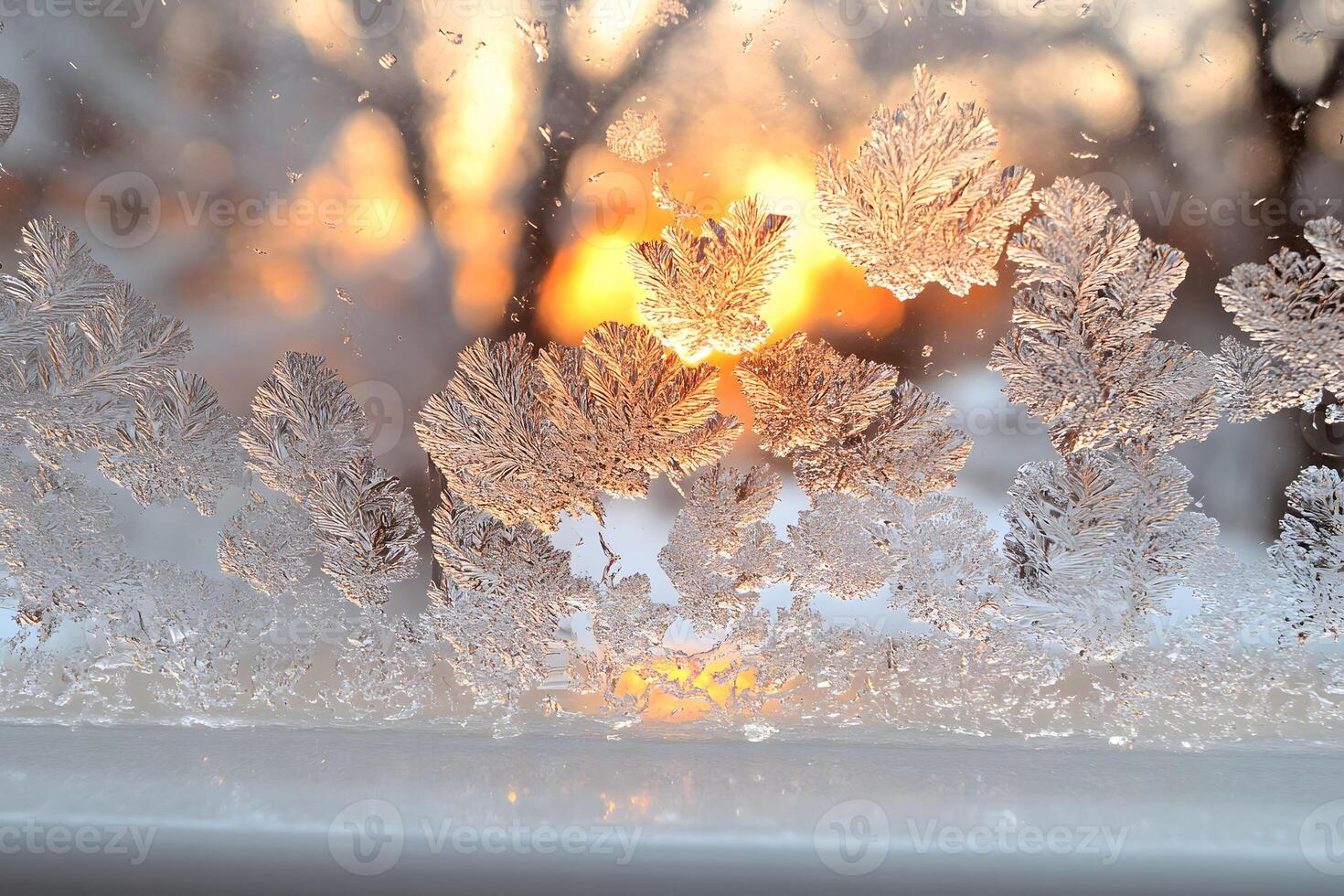 Delicate Frost Patterns on Windowpane with Golden Sunrise Backdrop photo