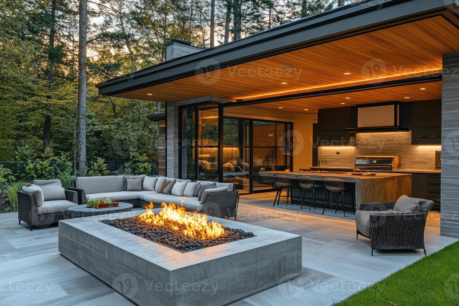 Modern outdoor kitchen and living space with fire pit at sunset photo