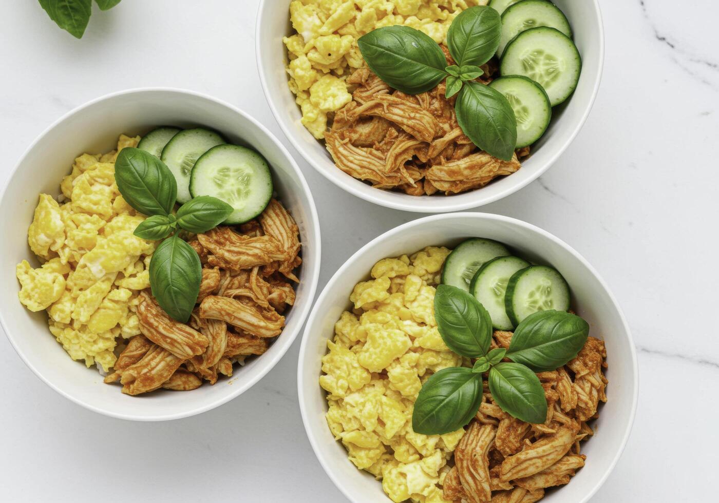 Three bowls with chicken, cucumbers and tomatoes photo