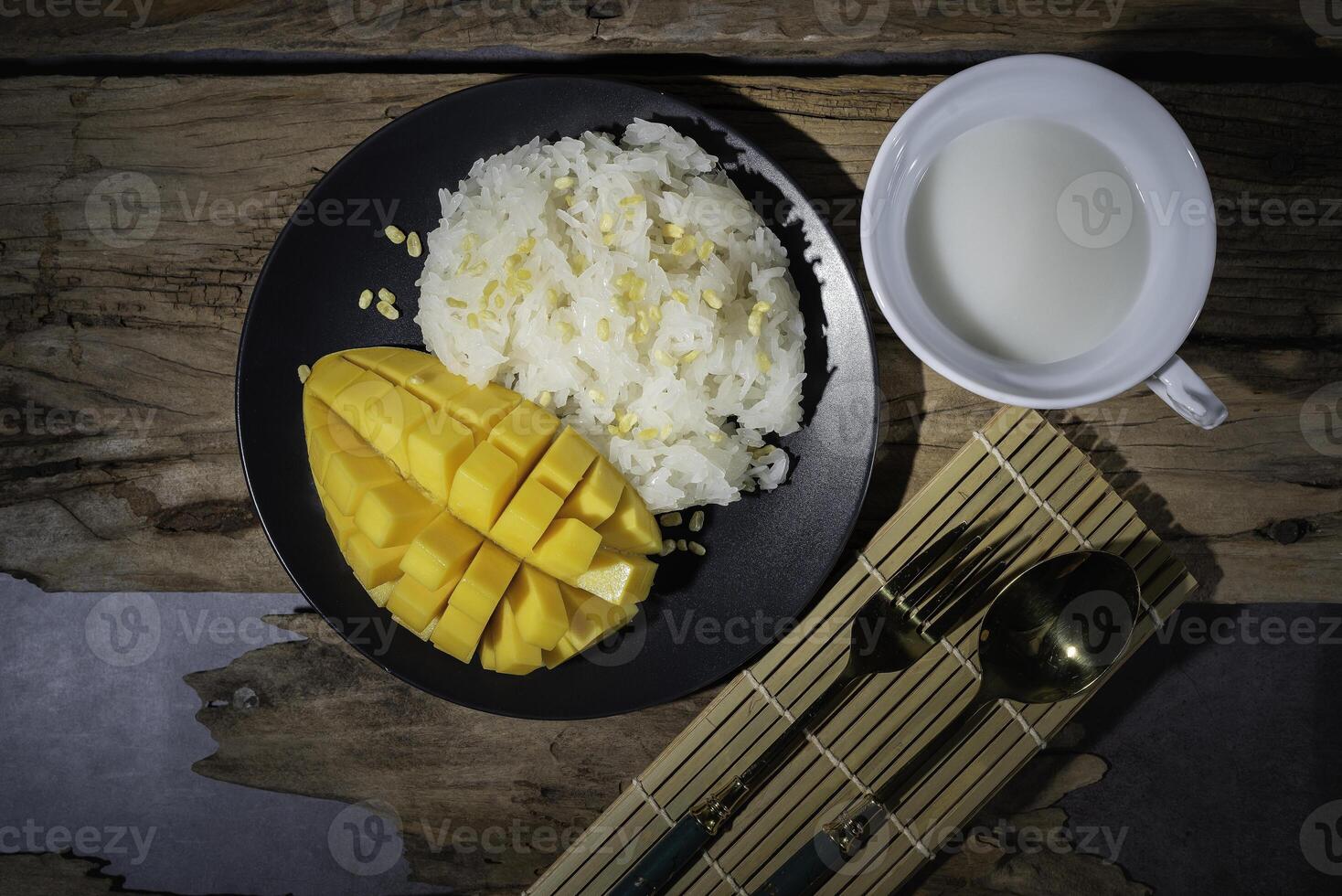Mango sticky rice, a Thai dish with an old wooden backdrop. This is very popular. photo