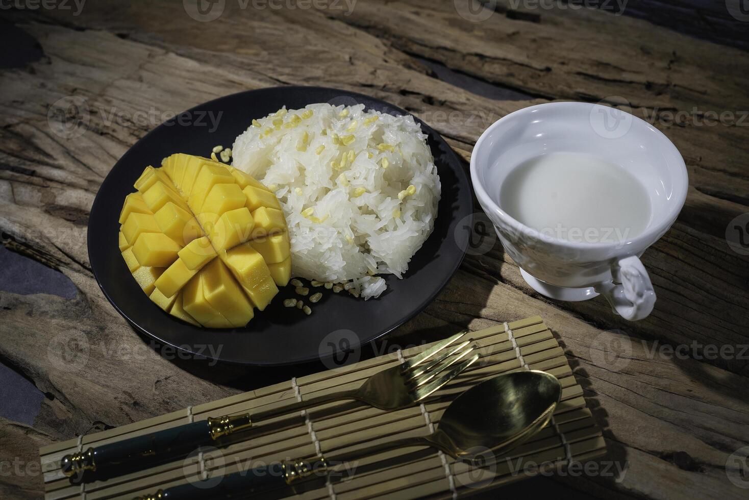 Mango sticky rice, Thai food, with an old wooden backdrop. This food is very popular in Asian countries. Thailand has coconut milk in a white cup, delicious taste. photo