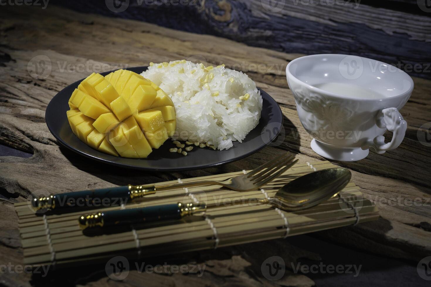 Mango sticky rice, Thai food, with an old wooden backdrop. This food is very popular in Asian countries. Thailand has coconut milk in a white cup, very delicious. photo