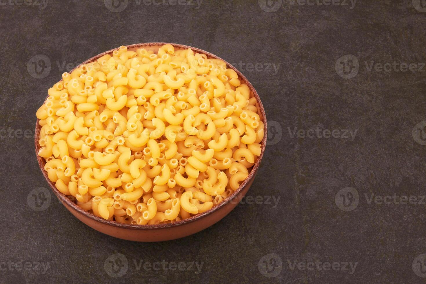 Elbow macaroni on black as a background photo