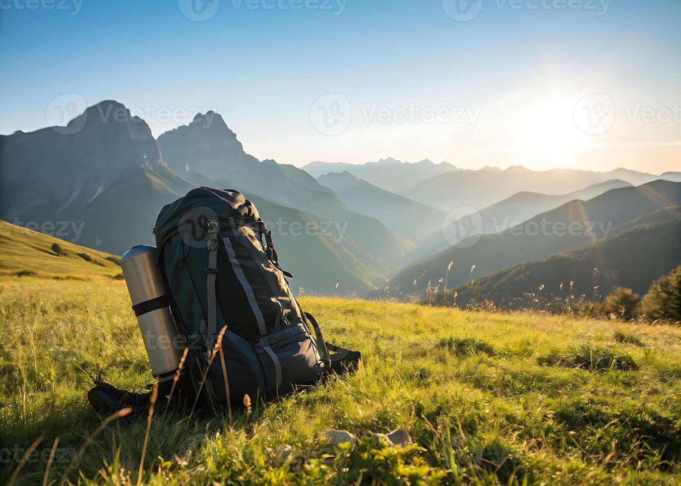 Hiking backpack. A hiking backpack placed on a rocky trail with scenic mountains in the background on a sunny day photo