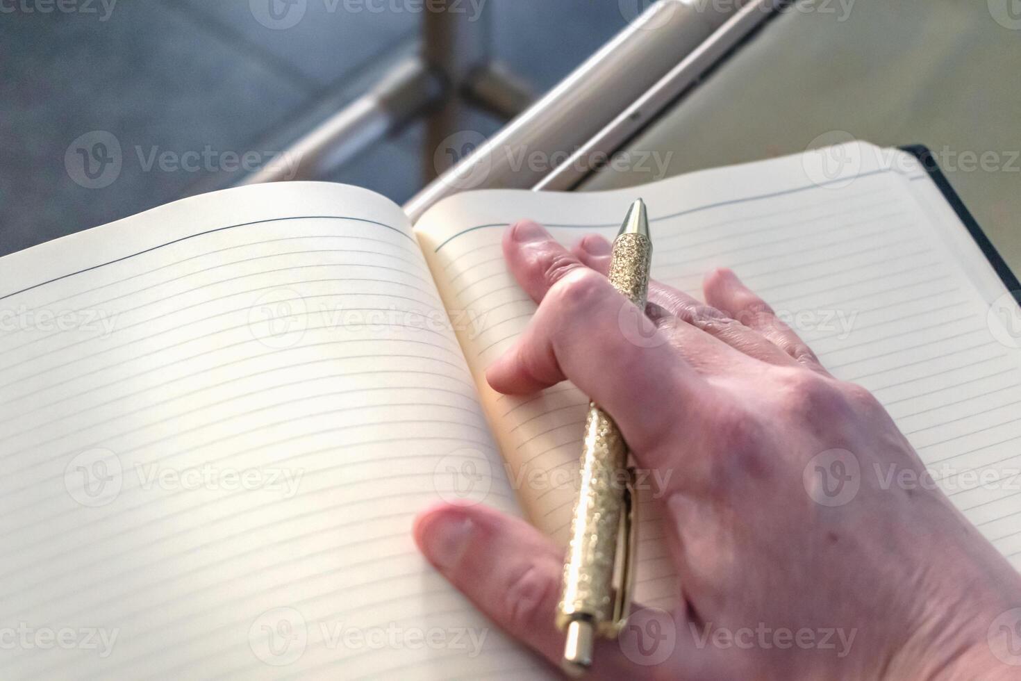 Woman writing in a notebook with a pencil, memory photo