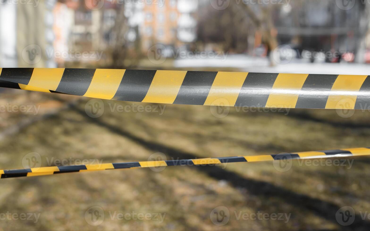 A yellow and black striped tape is placed on the ground photo