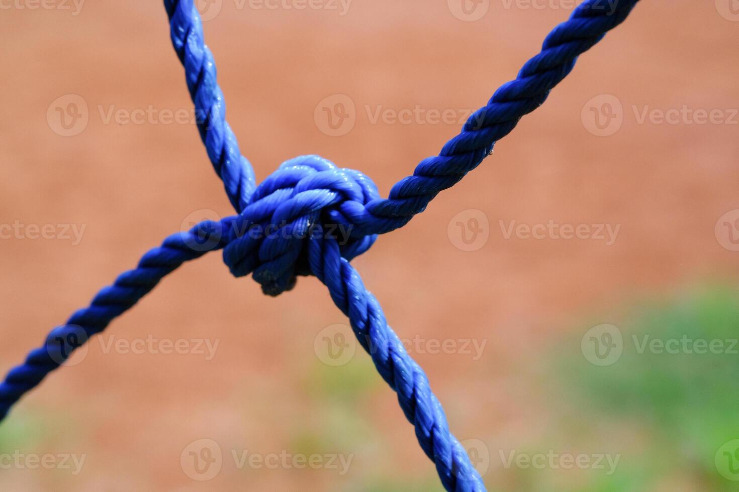 Macrophotography Blue plastic rope knot. Closeup shot of knot rope of goal net. Knots and braids. Sports and entertainment. Textured Wallpapers. Copy space. Bokeh shots. Graphic Design photo