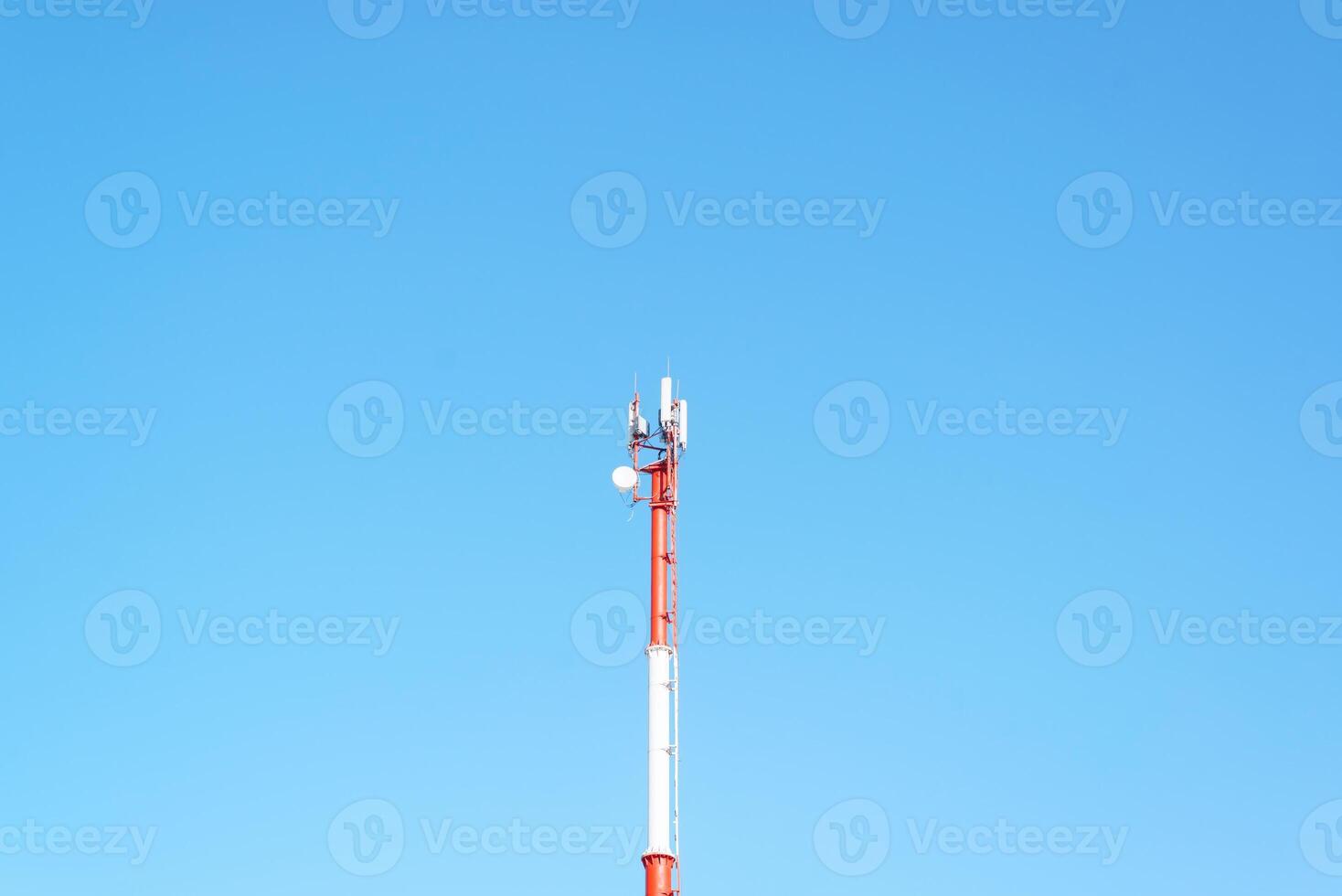 Mobile tower of cellular, radio and internet communications against the background of a clear blue sky photo