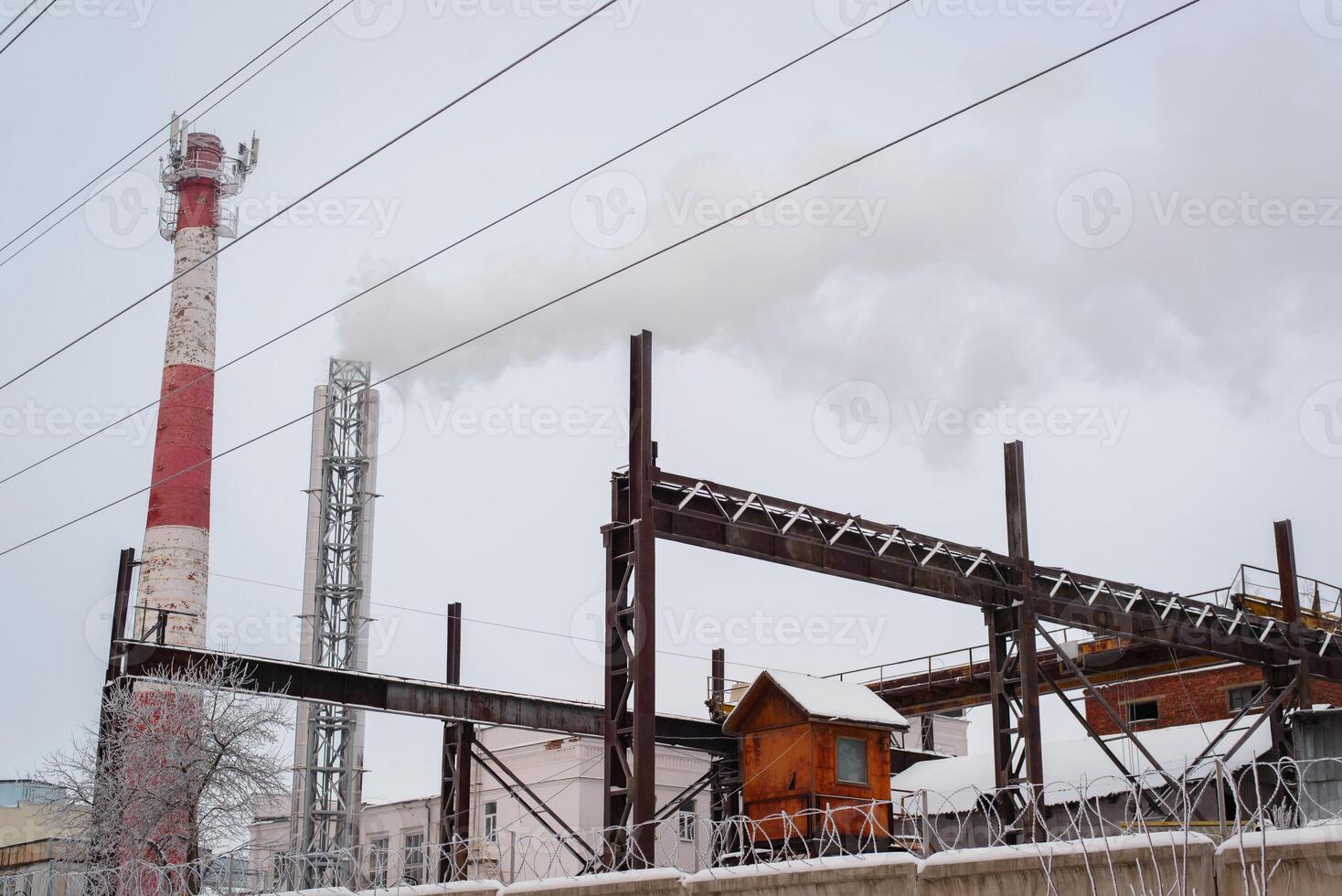 Old factory, rusty structures and a smoking chimney. Air pollution. Russia, Smolensk 01.23.2021 photo