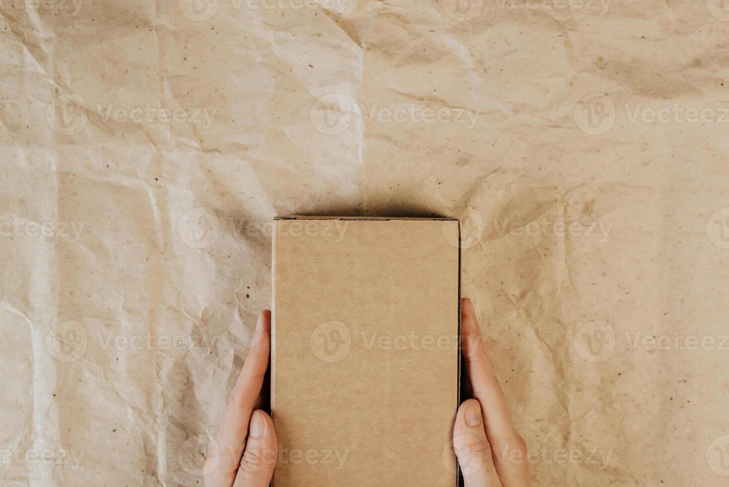 Male hands holding cardboard box. Top view, layout. Delivery concept. Place for text, logo, ads photo