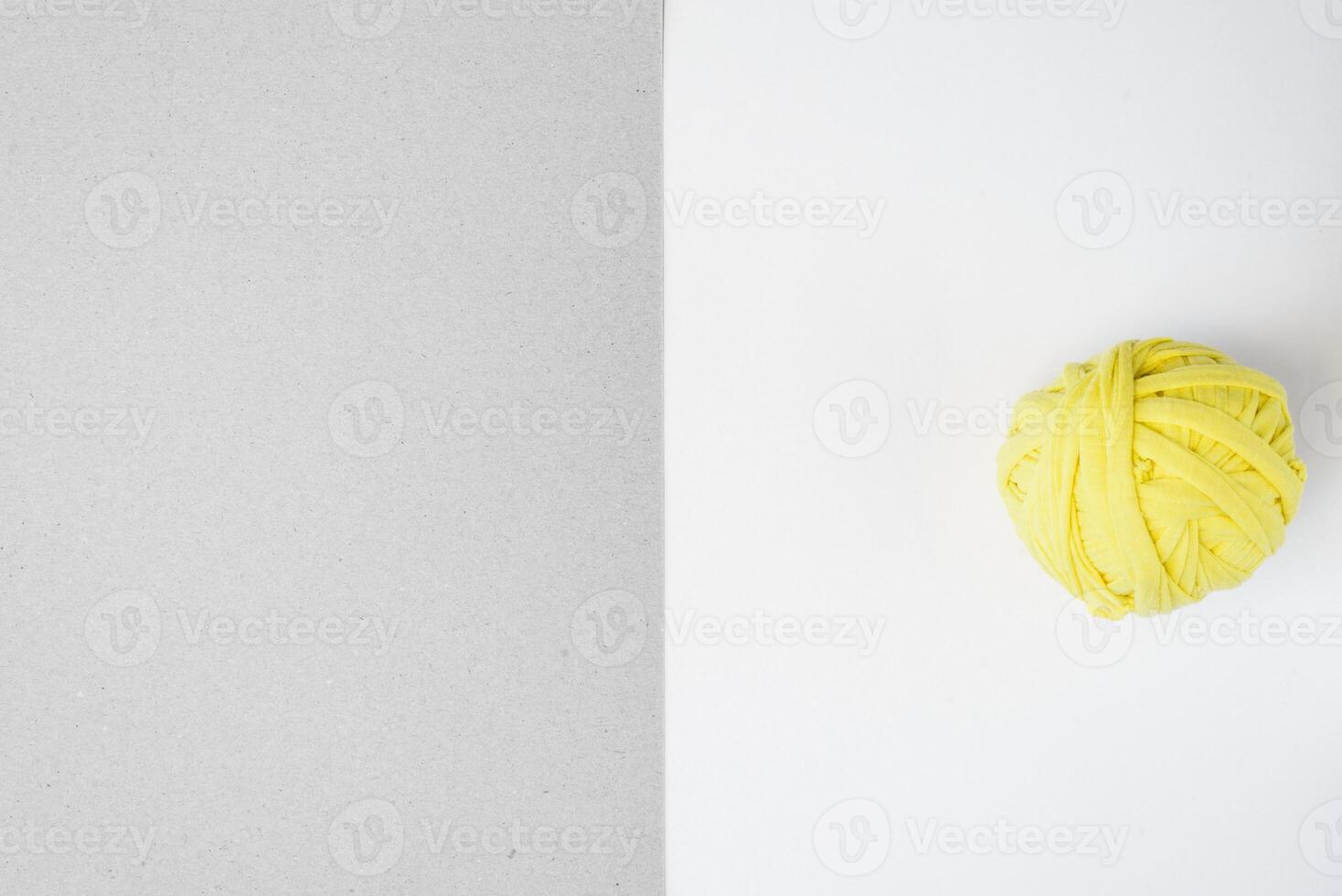 Yellow rag ball and gray cardboard. Trending colors of 2021. Flat lay, copy space photo