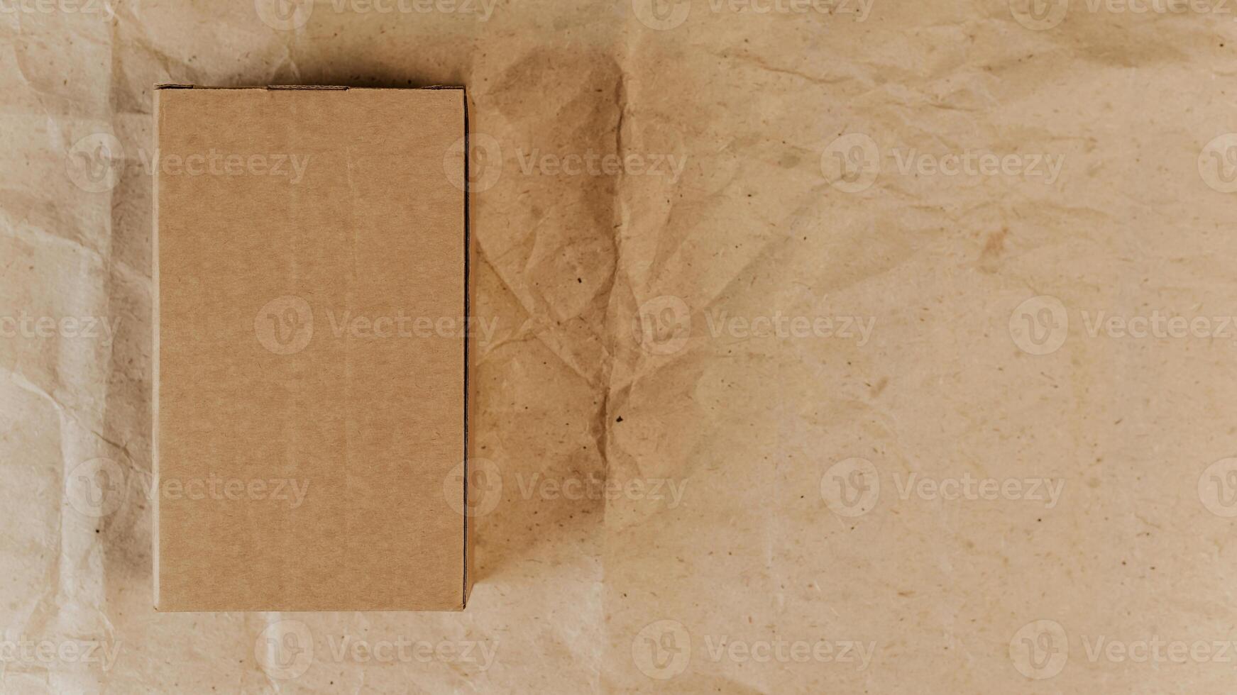 Brown cardboard box and wrapping paper. Top view, mockup. Place for logo, announcement, text. Gift, delivery concept photo