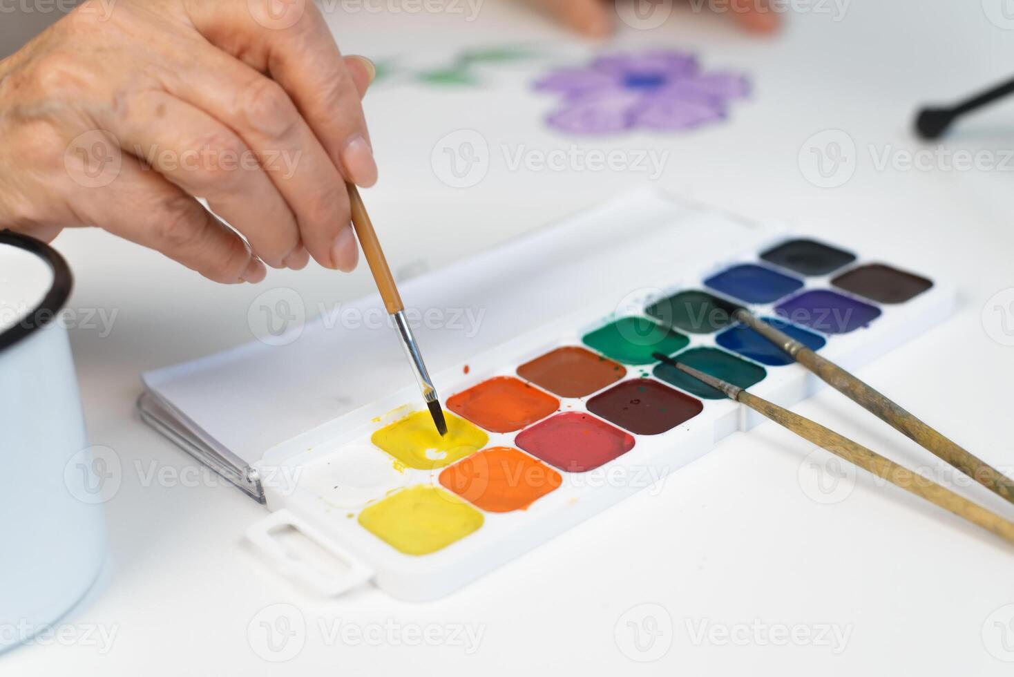 A woman is painting with watercolors and brushes photo