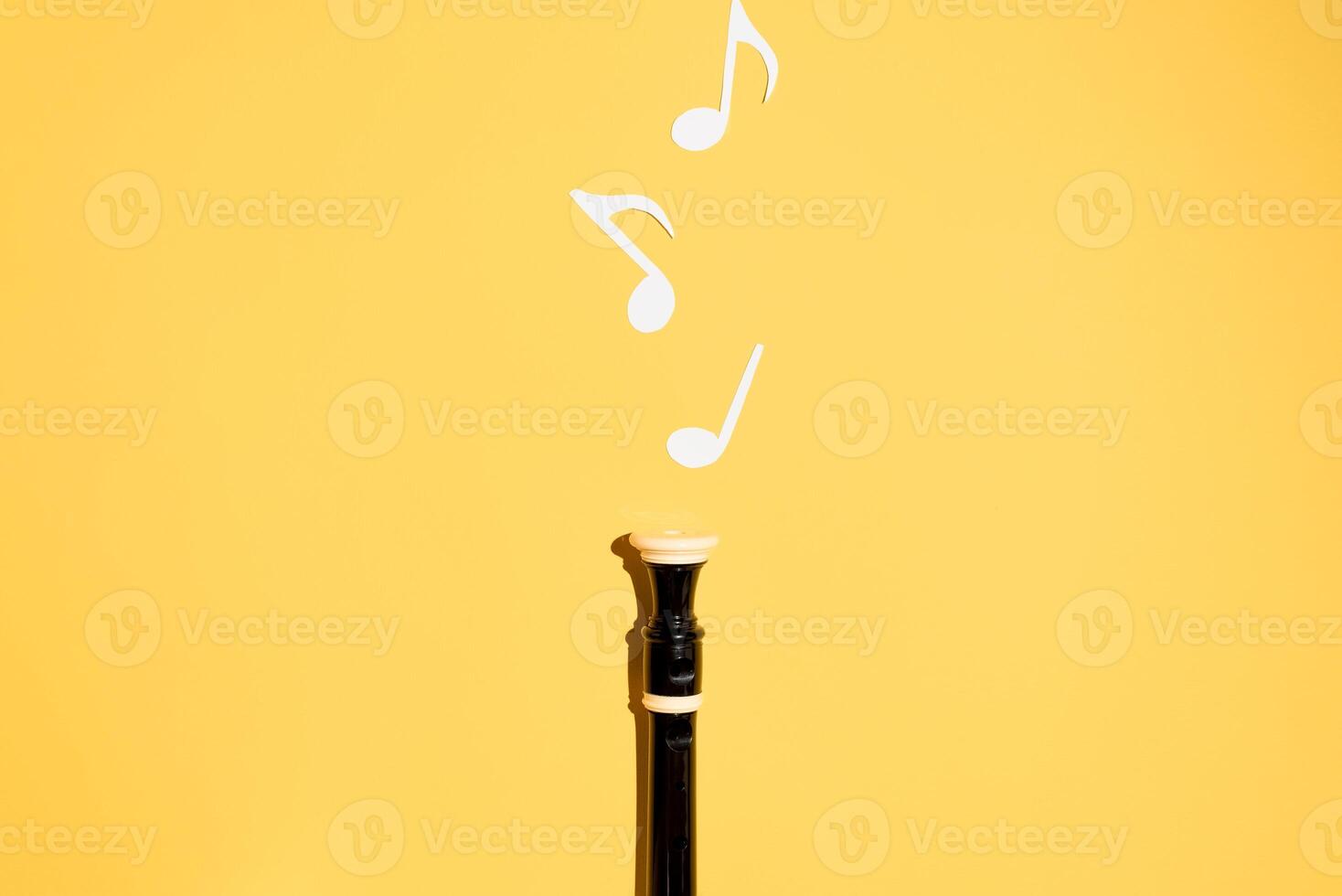 Musical flute and notes, flat lay on a yellow background. Copy space photo
