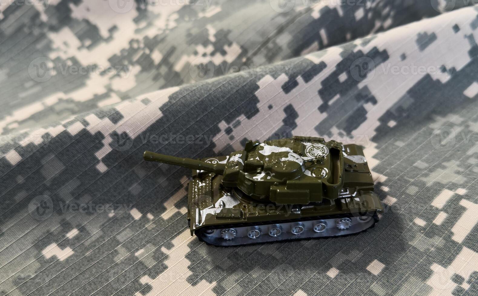 Camouflage toy tank on military background photo