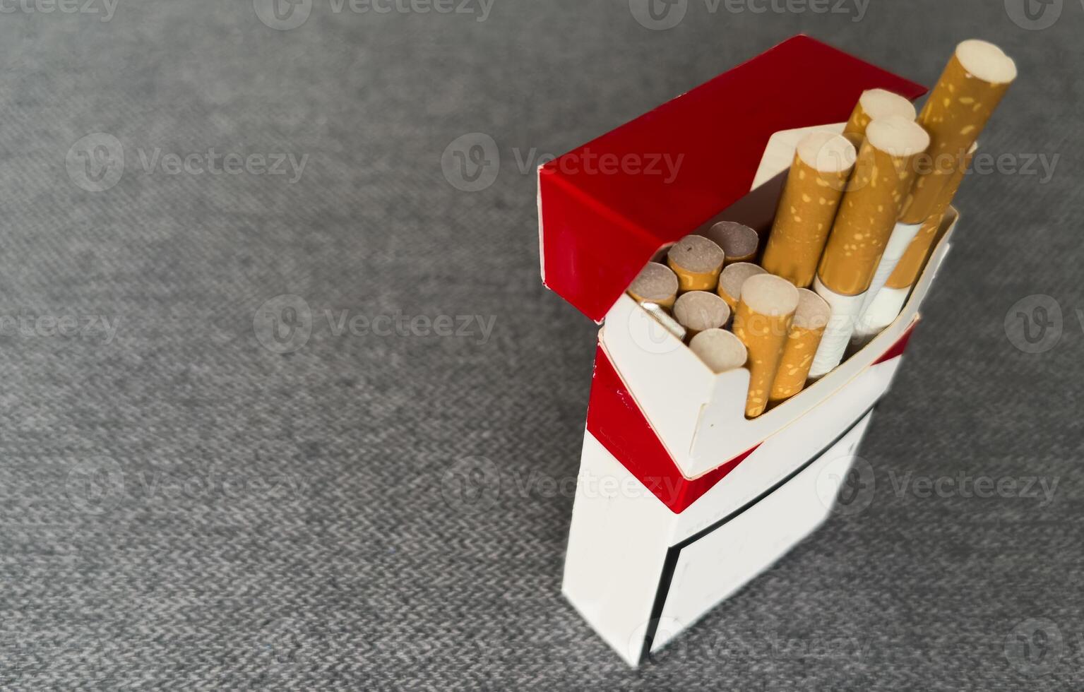 Cigarettes in a pack. Yellow filter. Harm to health. Bad habit. A pack of cigarettes on the table. open pack of cigarettes. photo