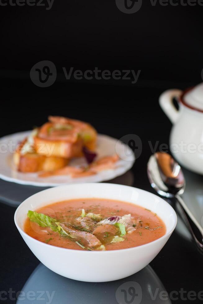 Dietary fish soup-puree with salmon, isolated on black background. Dietary simple lunch. photo