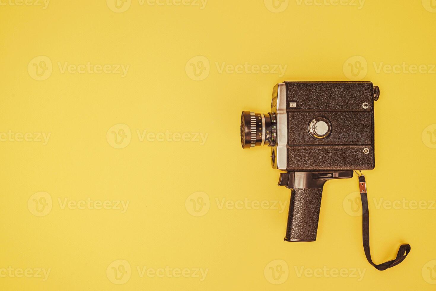 Classic film camera positioned on a bright yellow surface photo
