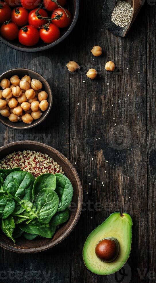 Healthy ingredients including avocado, spinach, chickpeas, and tomatoes on a rustic surface photo