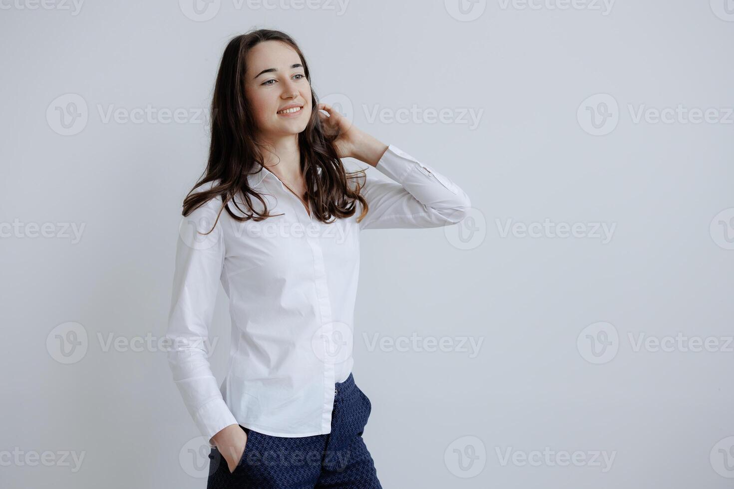 Young woman poses confidently in a stylish outfit, showcasing modern fashion trends in a minimalistic studio setting photo