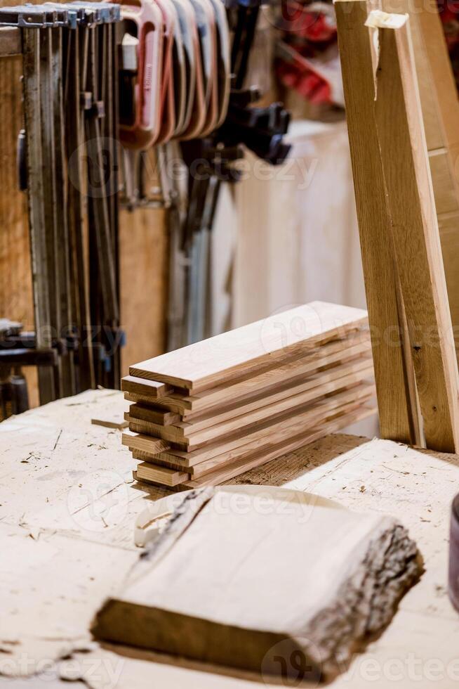 Woodworking tools and neatly stacked lumber in a rustic workshop during daylight photo