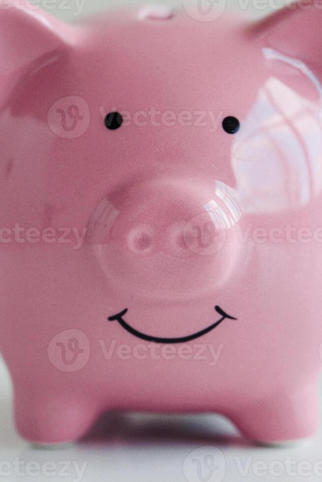 Cute pink piggy bank smiling happily on a bright background ready to hold savings for future adventures photo