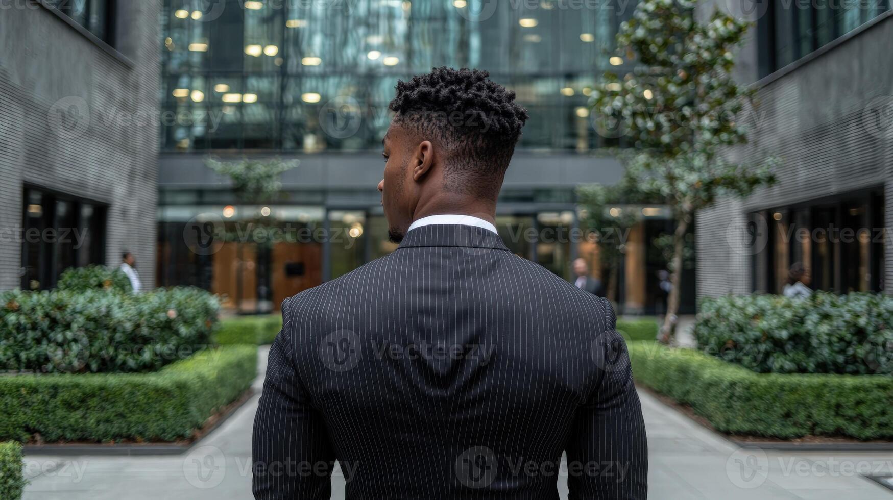 A businessman in a suit stands in a modern city environment photo