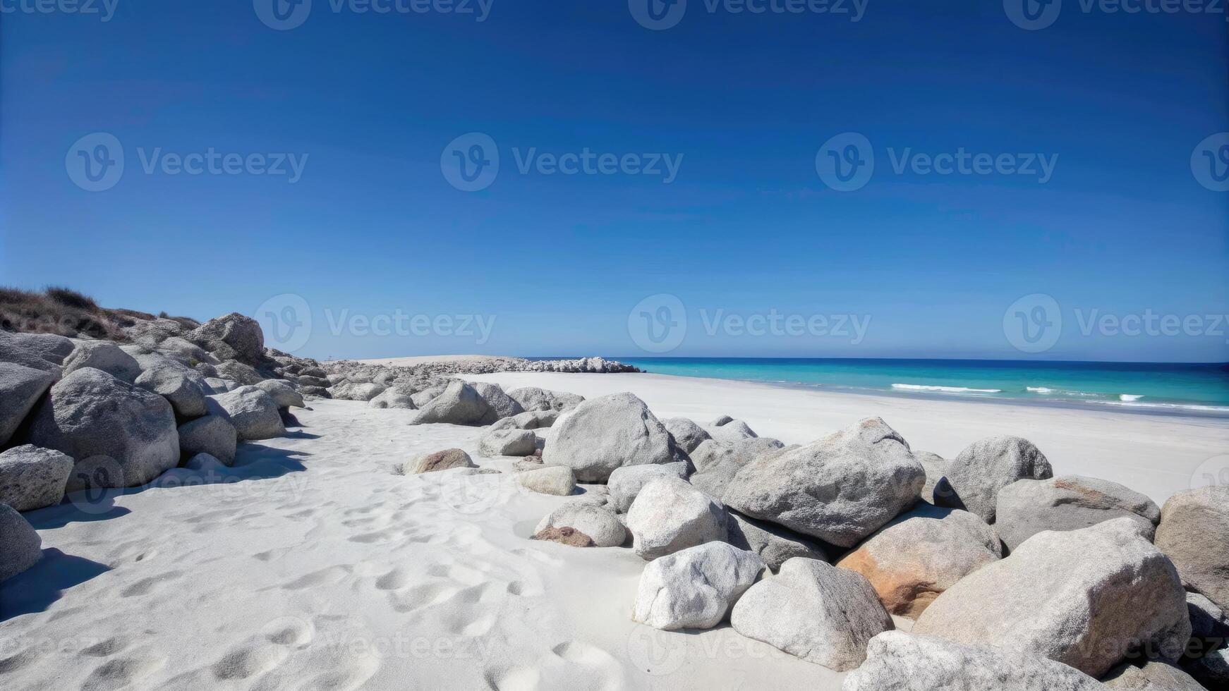 Rocky shoreline with white sand and a clear blue sky. photo
