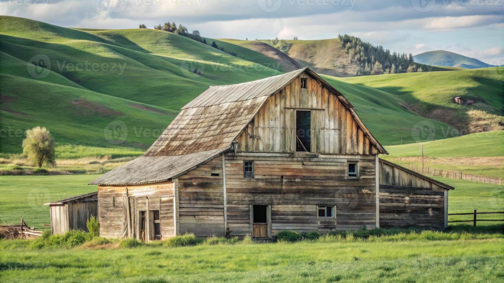 Rustic barn nestled in rolling green countryside hills. photo