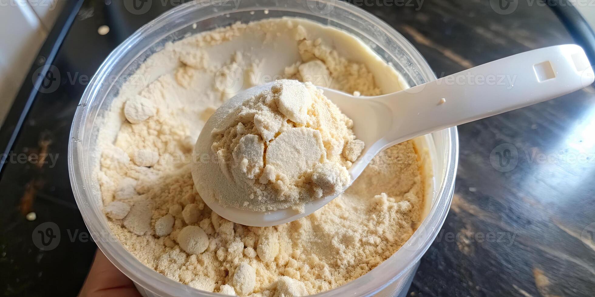 Measuring scoop filled with fine white powder in a container. photo